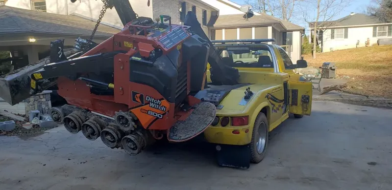 Equipment transport Nashville TN - bobcat skid steer being loaded onto professional flatbed trailer