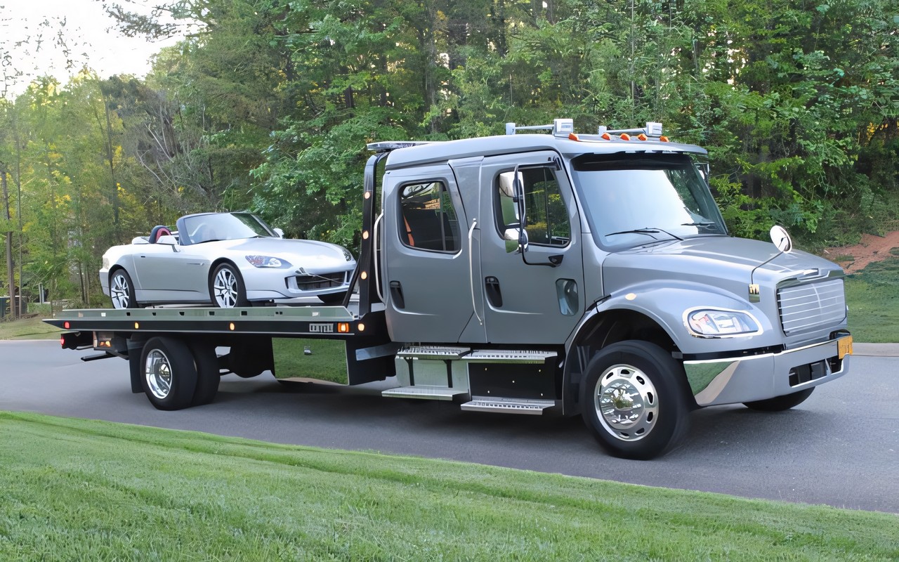Professional flatbed tow truck transporting Porsche sports car - reliable Nashville towing company