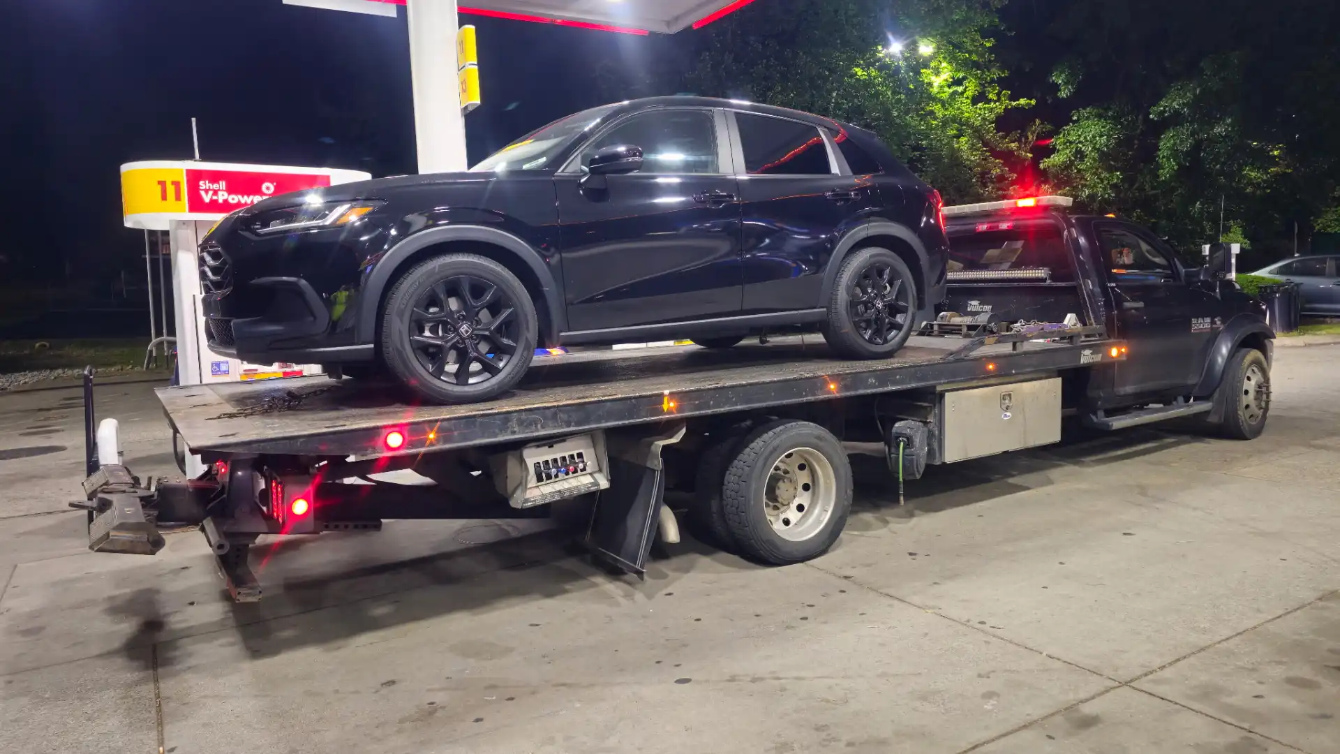Black Honda HR-V crossover loaded on a Hook Em' Up Towing flatbed at a Nashville Shell station