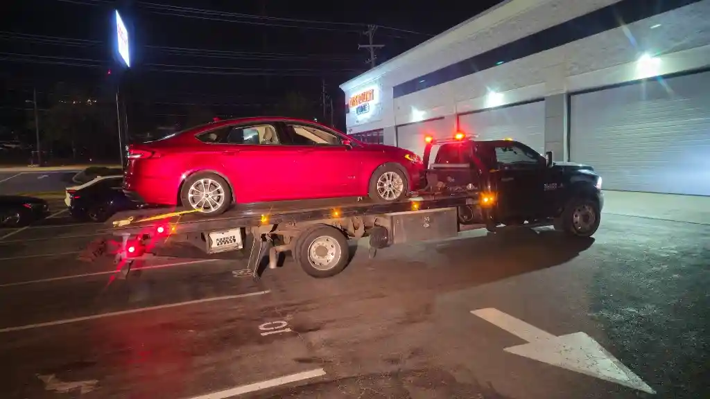 Hook Em' Up Towing flatbed responding to a no-start vehicle with a failed alternator on a Nashville street at night