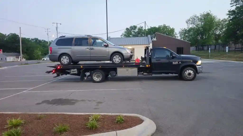Hook Em' Up Towing flatbed loaded with a Kia Sedona minivan after a crash near a Nashville intersection