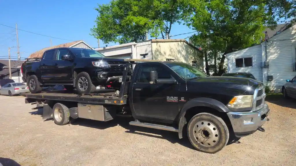 Hook Em' Up Towing flatbed loaded with a black Chevrolet Colorado pickup in Nashville