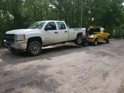Pickup truck lifted by a wheel-lift tow truck in Nashville