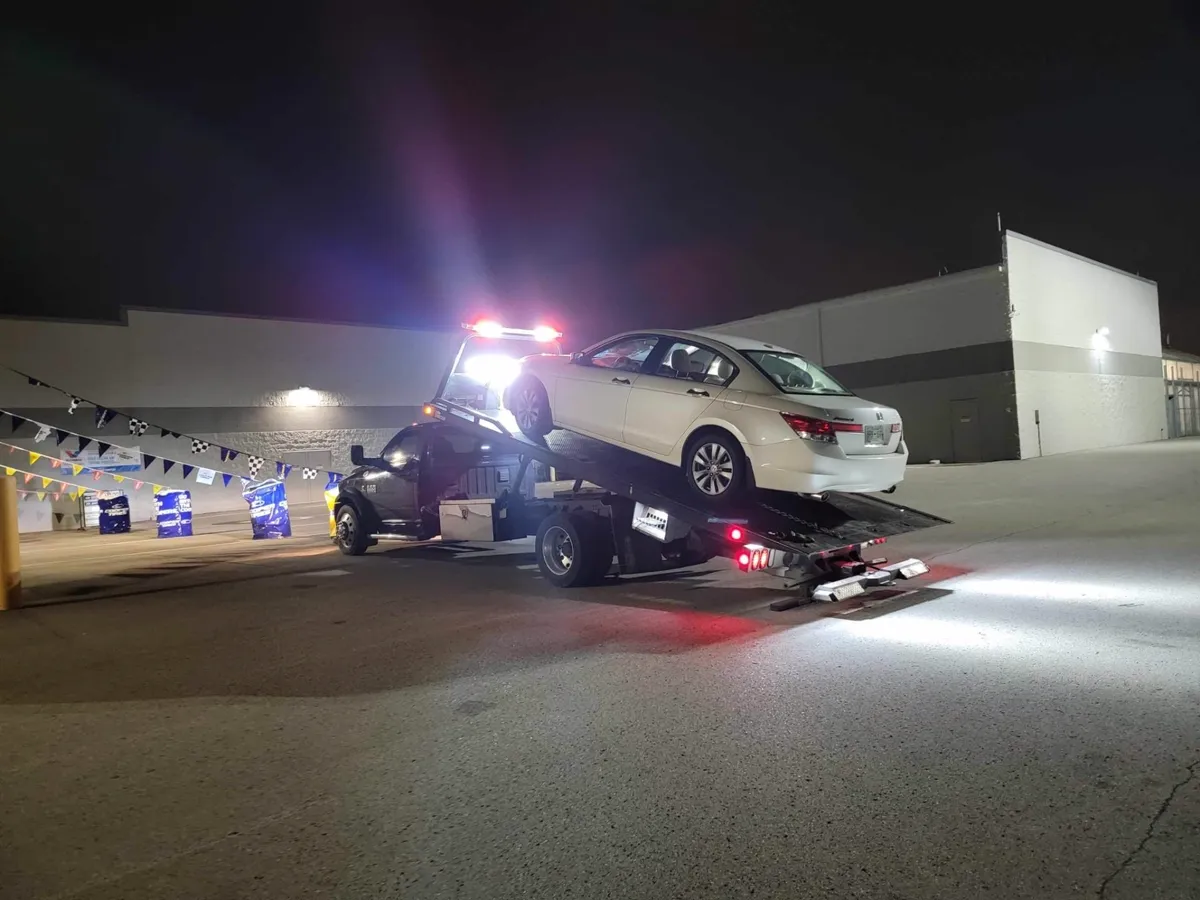 Honda being winched onto a flatbed at night in Nashville