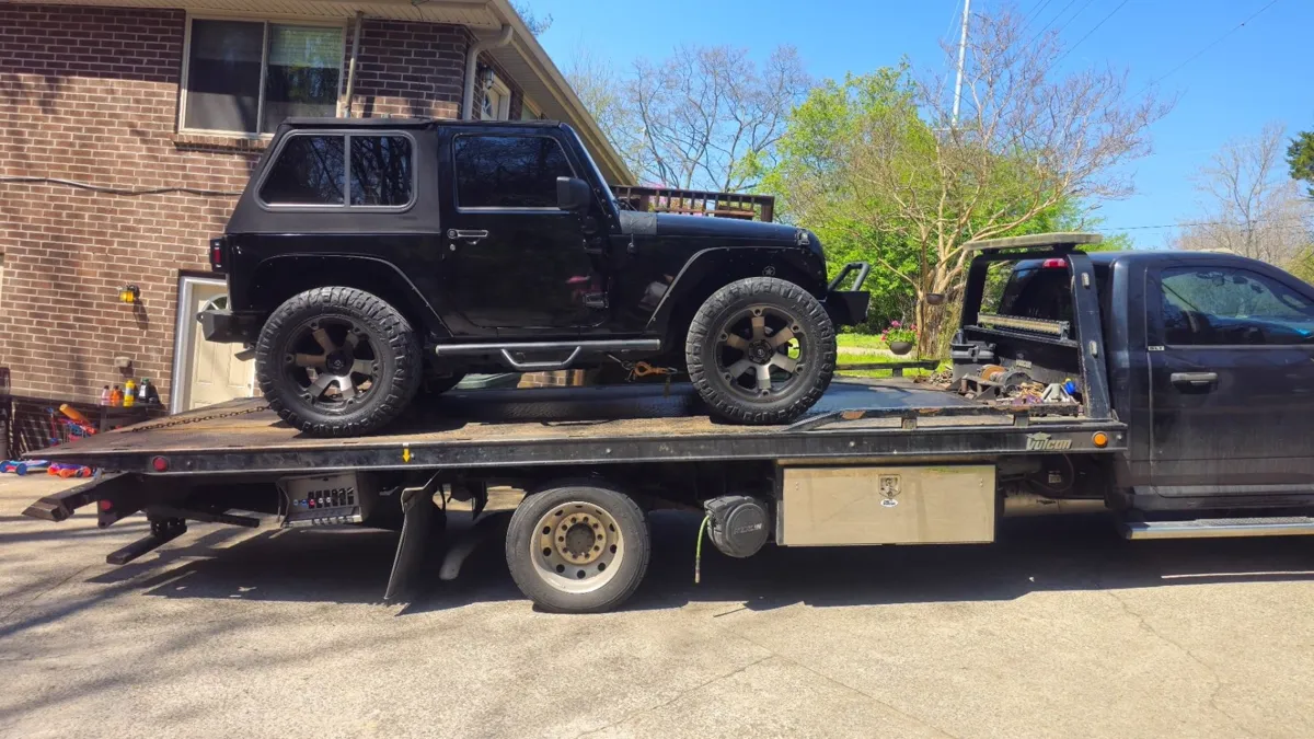 Jeep secured on a Hook Em' Up Towing flatbed in Nashville